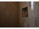Close-up of the shower with gray geometric tile and shower niche for added convenience at 2831 N Perry St, Denver, CO 80212