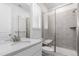 Bright bathroom featuring a modern vanity and a walk-in shower with gray tile and a built-in seat at 15774 W Girard Ave, Morrison, CO 80465