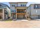 Contemporary two-story home featuring a stone-accented facade, upper balcony, and a convenient drive-under two-car garage at 15774 W Girard Ave, Morrison, CO 80465