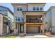 Contemporary two-story home featuring a stone-accented facade, upper balcony, and a convenient drive-under two-car garage at 15774 W Girard Ave, Morrison, CO 80465