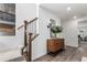 Bright foyer featuring modern wood floors, a wooden dresser, and stairs with black iron railings at 15774 W Girard Ave, Morrison, CO 80465