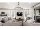 Cozy living room featuring a large sectional, modern lighting, and seamlessly connecting to the kitchen with a view to the outdoors at 15774 W Girard Ave, Morrison, CO 80465