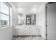 The main bathroom features double sinks, a large vanity mirror, and marble floors at 15774 W Girard Ave, Morrison, CO 80465