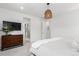 Bright main bedroom with a decorative light fixture, flat screen TV, and ensuite bath at 15774 W Girard Ave, Morrison, CO 80465