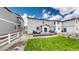 Landscaped backyard featuring a small deck, green grass, and white picket fence at 1933 Villageview Ln, Castle Rock, CO 80104