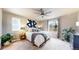 Serene bedroom features a plush bed, ceiling fan, natural light from two windows and modern decor at 1933 Villageview Ln, Castle Rock, CO 80104