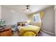 Inviting bedroom with a yellow bedspread, bright window, and comfortable desk for a cozy workspace at 1933 Villageview Ln, Castle Rock, CO 80104