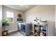 Functional laundry room with modern washer, dryer, and built-in shelving at 1933 Villageview Ln, Castle Rock, CO 80104