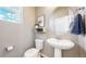 Stylish powder room featuring a pedestal sink, round mirror, and a decorative shelf with plant at 1933 Villageview Ln, Castle Rock, CO 80104