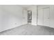 An empty bedroom featuring neutral gray carpet and sliding closet with a white door to another room at 8236 E Phillips Pl, Centennial, CO 80112