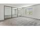 Bedroom boasts neutral gray carpet, natural light from a window, and a large mirrored closet at 8236 E Phillips Pl, Centennial, CO 80112