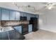 Kitchen with blue cabinets, sleek black appliances, and great counterspace at 8236 E Phillips Pl, Centennial, CO 80112
