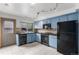 Well-lit kitchen featuring blue cabinets, sleek black appliances, and ample counter space at 8236 E Phillips Pl, Centennial, CO 80112