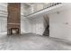 Spacious living room with a cozy fireplace and staircase leading to the upper level at 8236 E Phillips Pl, Centennial, CO 80112