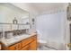Bright bathroom features a wooden vanity with granite countertop and shower with white curtain at 3083 S Xanthia St, Denver, CO 80231