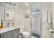 Modern bathroom featuring a gray vanity with white sink and glass enclosed shower at 3083 S Xanthia St, Denver, CO 80231