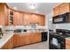 Modern kitchen with wooden cabinets, granite countertops, stainless steel appliances, and tile backsplash at 3083 S Xanthia St, Denver, CO 80231