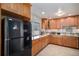 Bright kitchen featuring wooden cabinets, granite countertops, black appliances, and tile backsplash at 3083 S Xanthia St, Denver, CO 80231