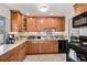 Modern kitchen featuring wood cabinets, granite counters, stainless steel appliances, and tile backsplash at 3083 S Xanthia St, Denver, CO 80231