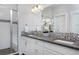 Bright bathroom with double sinks, granite countertops, and a glass enclosed shower at 719 Robert St, Longmont, CO 80503