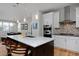Bright, modern kitchen with quartz countertops, stainless steel appliances, and an island with bar seating at 719 Robert St, Longmont, CO 80503
