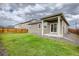 Backyard featuring a well-maintained lawn, partial patio, and wooden fence at 13667 Valentia St, Thornton, CO 80602