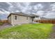 Backyard featuring a well-maintained lawn, partial patio, and wooden fence at 13667 Valentia St, Thornton, CO 80602