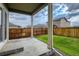 View of the backyard and patio with green grass and a wooden fence at 13667 Valentia St, Thornton, CO 80602