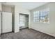 Carpeted bedroom with large window providing natural light and walk-in closet with shelving at 13667 Valentia St, Thornton, CO 80602