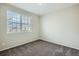 Carpeted bedroom with large window providing natural light and neutral color scheme at 13667 Valentia St, Thornton, CO 80602