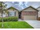 The front exterior of a house with a manicured lawn, brick accents, a front door, and an attached garage at 13667 Valentia St, Thornton, CO 80602