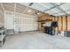 Spacious garage with a concrete floor, a metal storage rack on the back wall, and a white door at 13667 Valentia St, Thornton, CO 80602