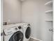 Laundry room with front loading washer and dryer, and shelves for storage at 13667 Valentia St, Thornton, CO 80602