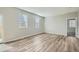 Living room featuring wood-look flooring, neutral paint, and large windows that provide natural light at 13667 Valentia St, Thornton, CO 80602