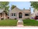 Charming stucco home featuring a quaint arched entryway and a well-maintained lawn at 848 Harrison St, Denver, CO 80206