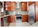 Well-lit kitchen features stainless steel appliances, tiled floors, and wooden cabinetry for a modern look at 848 Harrison St, Denver, CO 80206