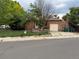 Charming brick home featuring an attached garage, stone chimney, and fenced front yard at 595 W Eastman Ave, Englewood, CO 80110