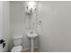 Clean, minimalist half bathroom with pedestal sink and neutral color scheme at 10578 E Jewell Ave, Aurora, CO 80012