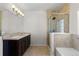 A stylish bathroom showcases tile floors, glass shower, separate soaking tub, and double sinks at 10578 E Jewell Ave, Aurora, CO 80012