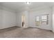 A primary carpeted bedroom boasts neutral walls, a door to a bathroom, and a door to an outdoor patio at 10578 E Jewell Ave, Aurora, CO 80012