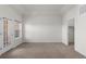 A bright bedroom features neutral carpet, tray ceiling, a door to a walkout, and a large walk-in closet at 10578 E Jewell Ave, Aurora, CO 80012