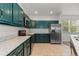 Spacious kitchen featuring green cabinets, light countertops, and stainless steel appliances at 10578 E Jewell Ave, Aurora, CO 80012