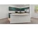 Modern kitchen with green cabinets, stainless steel appliances, and island sink at 10578 E Jewell Ave, Aurora, CO 80012