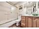 Bathroom featuring a shower-tub combination, vanity, and decorative mirror at 19475 Stag Ln, Monument, CO 80132