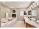 Bathroom features a soaking tub with fireplace, dual vanities, and neutral color palette at 19475 Stag Ln, Monument, CO 80132