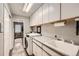 Bright laundry room with a utility sink, ample cabinetry, and washer and dryer at 19475 Stag Ln, Monument, CO 80132
