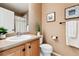 Clean bathroom with wood vanity, toilet, and shower at 10654 Ashfield St, Highlands Ranch, CO 80126