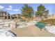 Green metal benches and large rocks in a snow-covered residential park at 10654 Ashfield St, Highlands Ranch, CO 80126