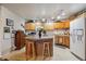 Functional kitchen with a center island, seating, and warm oak cabinets, perfect for cooking at 7131 S Wenatchee Way # F, Aurora, CO 80016
