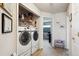 A convenient laundry room with modern, front-load washer and dryer, built-in storage and shelving at 7131 S Wenatchee Way # F, Aurora, CO 80016